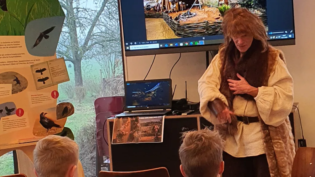 Kinderen leren prehistorische ambachten van Adaam de boer